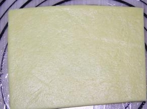 放上硅胶垫铺上保鲜膜，把面团放上用擀面仗擀成长方形，厚度0.5cm.