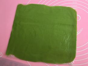 另外一个抹茶面团垫保鲜膜擀成20×20的正方形片。放入冰箱冷藏30分钟