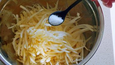 土豆擦成丝（最好是用粗一些的擦子，这样口感好），加盐拌匀