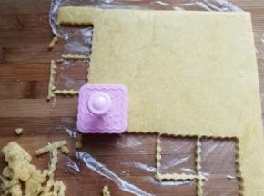 把冻硬的面皮取出来，撕开保鲜膜，再用饼干模具刻下饼干胚