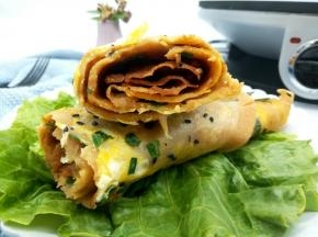 又香又脆的煎饼果子就这样做好了，咬一口煎饼果子，有鸡蛋的香味，还有黄豆粉的豆香味、当然还有馄饨片的嘎嘎脆，别提多好吃了！不要说孩子，我自己都吃了好几个，他们爷俩都说好吃，晚上下班让我再接着做，看来这是吃上瘾了！