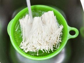 首先将金针菇去根，用手把粘在一起的金针菇撕开，用清水洗干净，再捞出淋干水分备用。