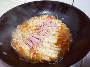 再把切好火腿放入锅中，盖上锅盖，大会烧开至金针菇段生。