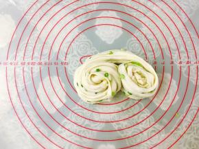 接着两边同时向中间卷起来，卷的时候边拉扯面团。