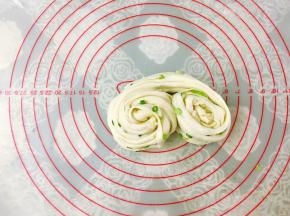 接着两边同时向中间卷起来，卷的时候边拉扯面团。