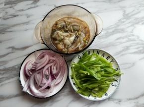 我们利用这个时间来切配菜，把洋葱去皮，切丝，我只用了半个洋葱，量可以根据自己喜欢增加，青椒洗干净，去根，去籽再切丝。准备工作完成。