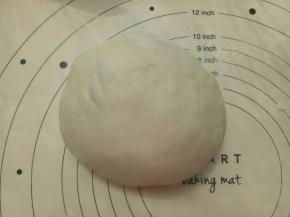 取出面团用手再次揉圆盖保鲜膜松弛20分钟。