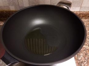 热锅倒油烧至八成热。