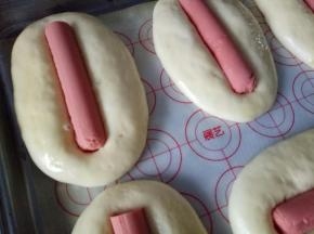 将火腿肠放到面包中间按压到底