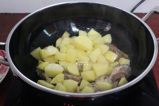 把土豆加入，翻炒，至微微的焦黄；