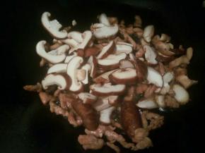 看肉丝变色后，翻炒几下，加香菇丝翻炒出香味