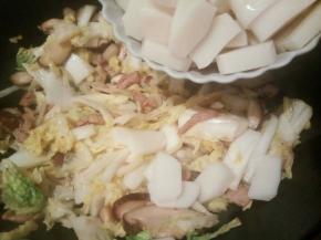 加入年糕片翻炒，白菜丝会出汤，年糕翻炒一会就好了