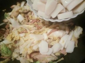 加入年糕片翻炒，白菜丝会出汤，年糕翻炒一会就好了