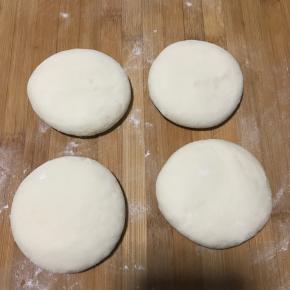 发酵好后继续揉面进行排气，然后分成四个均等的小剂子，压扁。