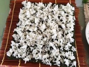 紫菜放寿司帘上，将米饭铺在紫菜上