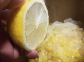 把柠檬切成两半，把汁水挤进面包桶内。