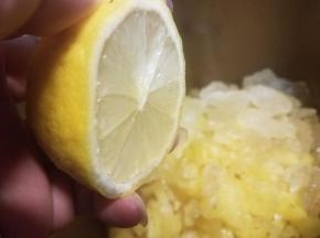 把柠檬切成两半，把汁水挤进面包桶内。