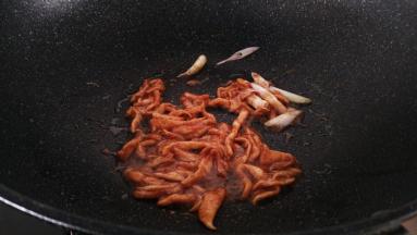 锅中放入油，小火加热，放入葱段和肉丝中火翻炒到变色盛出备用。