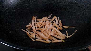 锅中留底油放入笋丝翻炒至变色。