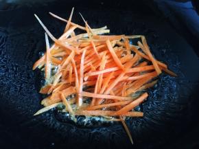 锅内放油烧热，放入胡萝卜丝炒软盛出备用