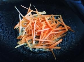 锅内放油烧热，放入胡萝卜丝炒软盛出备用