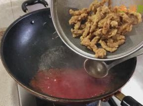 然后加入炸好的里脊肉翻炒，让里脊肉均匀的裹上酱汁