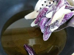 将侵泡的茄子捞出淋干水分，再用厨房用纸把茄子擦干，撒上干淀粉，使茄子均匀的沾上淀粉即可，这个方法炸茄子不会太吸油，炖出来的茄子不油不腻。