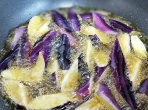 锅中倒入食用油，油温95度左右时把茄子用筷子夹入锅中，动作要快一点，但是不要一下子把茄子倒进锅里，那样淀粉也会倒入锅中，所以用最快的速度把茄子夹入油锅中，炸软，这个过程大约2分钟，捞出淋油备有。