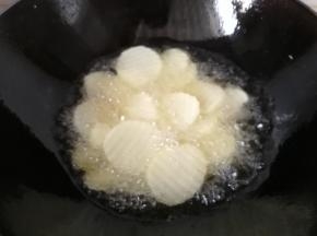 锅中倒入适量油烧至六七成热，下入土豆片开始炸