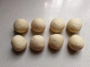 再把剩下的面团分成均匀的八份滚圆，盖保鲜膜静置十分钟左右