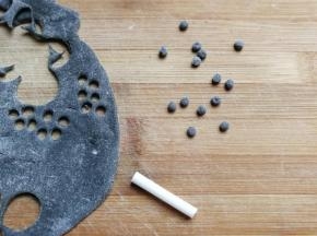 再继续用牛奶吸管，在面片上刻出8个小圆点，这些小圆点就是熊猫的鼻子