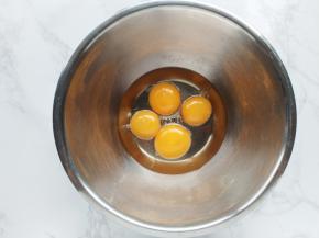 蛋白蛋黄分放在两个无水无油的盆中。蛋黄中加入玉米油，搅打均匀。