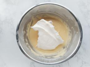 将三分之一的蛋白霜加入蛋黄糊中，用手动打蛋器拌匀。