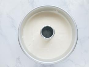 把面糊从高处倒入模具，按住烟囱在台面上震几下，震出气泡。