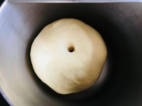 面团稍微按扁于容器中。覆盖保鲜膜发酵至两倍大。