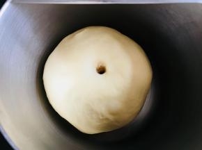 面团稍微按扁于容器中。覆盖保鲜膜发酵至两倍大。