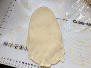 取一个面团，擀成牛舌型，底部搓薄。从上往下卷。周边有气泡用手拍掉。