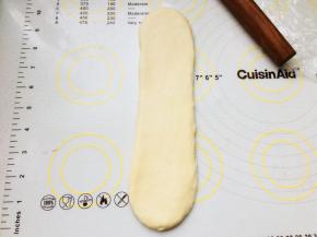 取一个卷，收口朝下。再次擀长。翻面，卷起来。