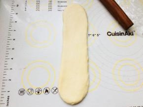 取一个卷，收口朝下。再次擀长。翻面，卷起来。