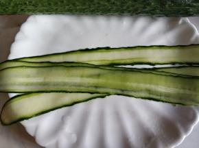 从黄瓜一头削下，尽量削薄。