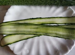 从黄瓜一头削下，尽量削薄。