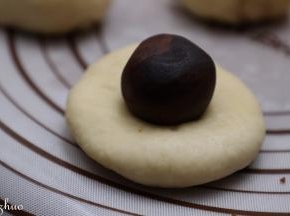 把面团用手按压扁包上豆沙馅，收口朝下。