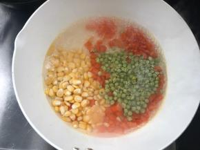 锅烧开水，先放入胡萝卜丁煮开，再加入青豆和玉米粒煮断生