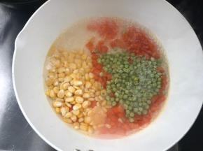 锅烧开水，先放入胡萝卜丁煮开，再加入青豆和玉米粒煮断生