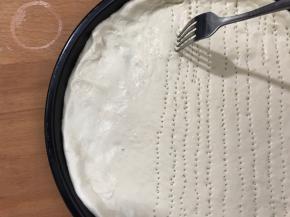 铺入披萨盘内，用叉勺插些眼（同时200度预热烤箱5分钟）