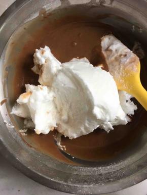 用刮刀将打发好的蛋白的3分之一放到可可蛋黄糊里，用蛋抽搅拌均匀！