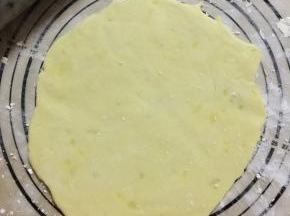 8、取出冷藏的面团，在硅胶垫上撒上一层低粉，把面团擀圆擀薄（视频中的操作方法更加便捷）