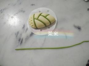 拿出绿色的面团，搓成细条，衔接在切痕上，完成。 室温28度发酵40分钟，蒸十分钟。