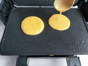 用勺子取一勺面糊垂直倒入煎饼机中。