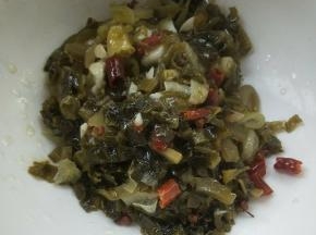 用漏勺捞出酸菜放大碗中。